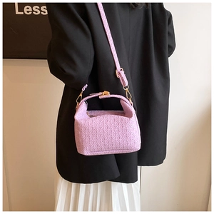 Detail of lavender woven crossbody bag showing textured pattern and gold hardware