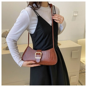 Détail du sac sous l'aisselle marron vintage avec motif crocodile et boucle dorée