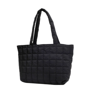 Minimalist black quilted tote bag in padded nylon featuring square grid stitching and soft handles