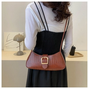 Détail du sac baguette marron à motif crocodile avec boucle dorée en fer à cheval