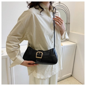 Gros plan sur le sac noir à motif crocodile avec une élégante boucle en métal doré