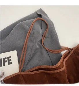 Close-up of brown suede tote bag with rope handles on a grey blazer background