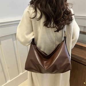 Grand sac cabas vintage marron foncé avec boucle dorée porté par un mannequin en hiver