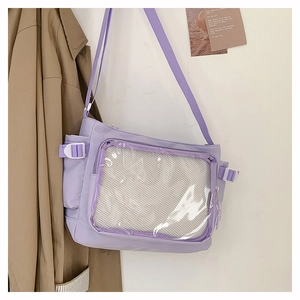 Detail of purple nylon messenger bag featuring a transparent PVC front pocket and white mesh