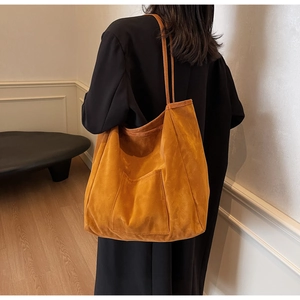 Close-up of caramel suede tote bag with front pocket showing soft velvet texture