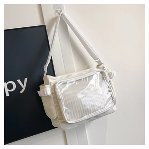 Close-up of white canvas tote with transparent PVC front window and side buckle detail