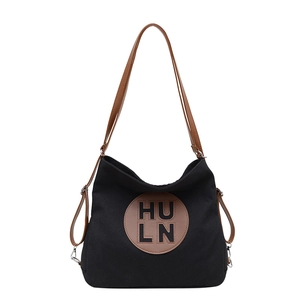 Minimalist black canvas tote bag with brown leather straps and HU LN logo branding