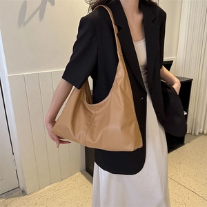 Minimalist caramel brown leather hobo shoulder bag with a spacious interior and wide strap