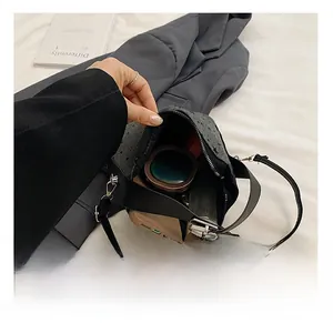 Detail showing internal capacity of the grey canvas bag with sunglasses and makeup