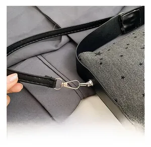 Detail of grey herringbone fabric handbag with black stars and metal lobster clasp