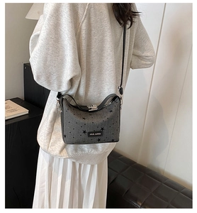 Detail of grey star print crossbody bag with rich rabbit tag and leather strap