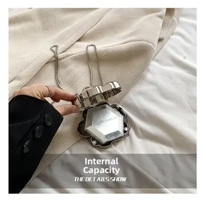 Macro view of flower-shaped silver metal evening bag showing compact interior and snake chain