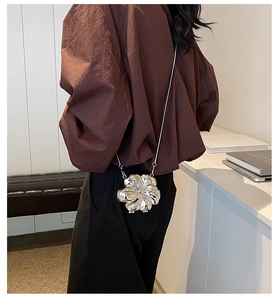 Silver flower evening bag with layered petals shown on model as a stylish crossbody chain bag