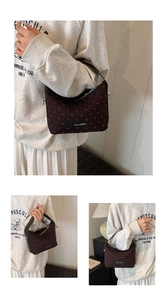 Detail of black canvas bag with red heart pattern and silver zipper closure feature
