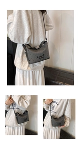 Detail shot of grey canvas crossbody bag with star print and leather strap