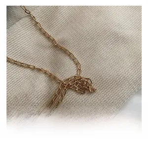 Detail of the high-quality gold chain links on a minimalist shell shoulder bag