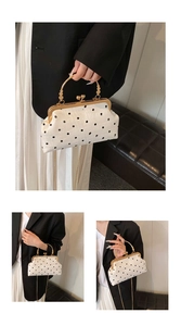 Detail of vintage polka dot kiss-lock handbag with gold hardware and chain strap