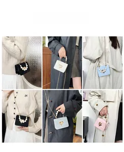 Detail of mini bag featuring pearl handle, gold heart lock, and elegant chain strap details