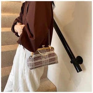 Detail of vintage kiss-lock bag with plaid fabric, lace accents and gold metal handle