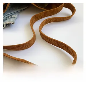 Détail de la large bandoulière sur un sac cabas en velours côtelé marron et doublure
