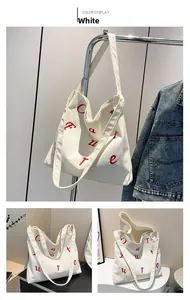 Détail du sac fourre-tout en velours côtelé blanc avec broderie rouge et tissu doux