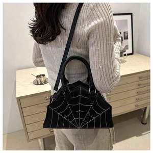 Detail of creative spider web stitching on black leather handbag with a cross-body strap