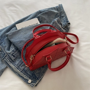 Detailed interior of red spiderweb handbag showing storage space for a smartphone