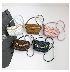 Flat lay of small crossbody bags with M-letter monogram prints and gold chain decor