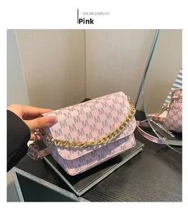 Detailed view of pink crossbody bag with M-letter prints and chunky gold chain