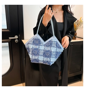 Détail d'un sac cabas en patchwork de denim bleu avec franges et ligne de tête en forme de V