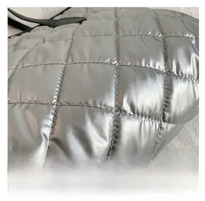 Détail du tissu matelassé argent métallique avec rembourrage carré sur le grand sac