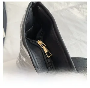 Gros plan d'une fermeture éclair dorée sur un sac cabas matelassé argenté brillant