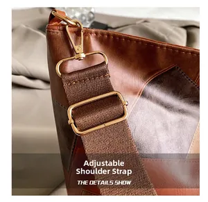 Detail view of adjustable shoulder strap with gold lobster clasp on contrast tote bag