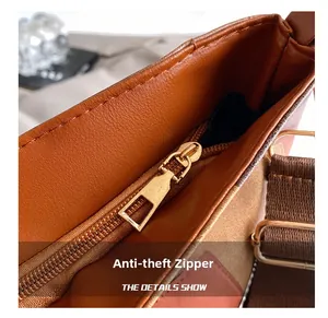 Detail of the high-quality gold anti-theft zipper and stitching on a brown leather tote