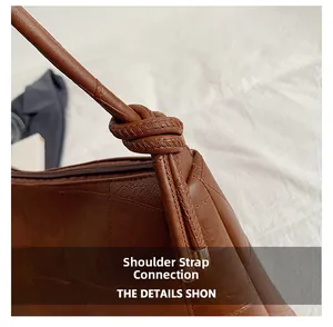 Close-up of the knot design on the shoulder strap of this dark brown leather tote bag