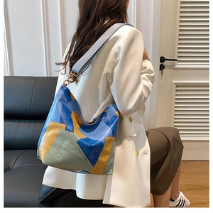 Retro color-block tote bag styled with a white blazer and navy skirt on a leather sofa