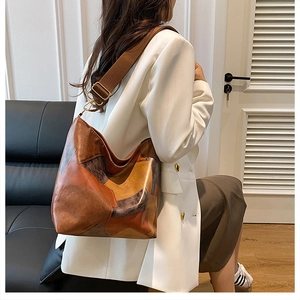 Detail of multi-color leather patchwork large tote bag with wide canvas shoulder strap