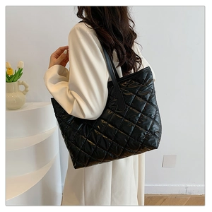Sac fourre-tout matelassé noir porté par un modèle montrant sa grande capacité et sa texture