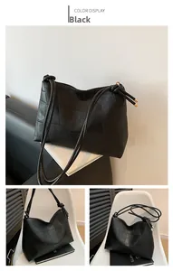 Detailed view of black woven patchwork leather texture and slim straps on large tote bag