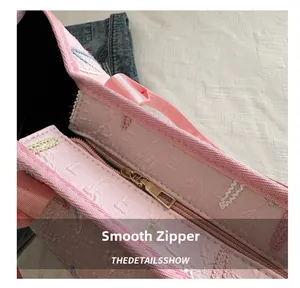 Détail du sac en tissu rose montrant la fermeture dorée et la texture florale 3D