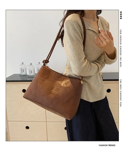 Brown patchwork leather tote bag with unique geometric stitching and knotted strap detail