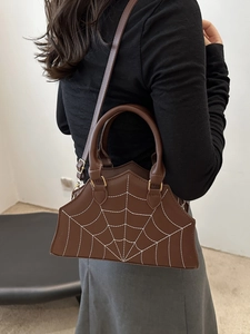 Brown leather handbag with white spider web stitching and adjustable shoulder strap