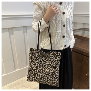 Detailed view of leopard print canvas tote bag styled with autumn layered outfit