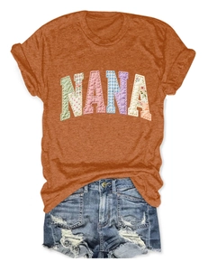 T-shirt orange avec motif NANA en patchwork et short en jean déchiré posés à plat