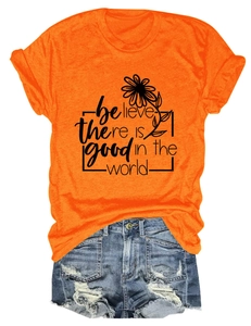 Détail du t-shirt orange à motif floral et du short en jean bleu délavé et déchiré