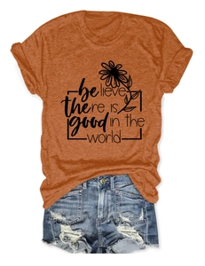 Détail du t-shirt orange avec imprimé floral et short en jean aux détails déchirés