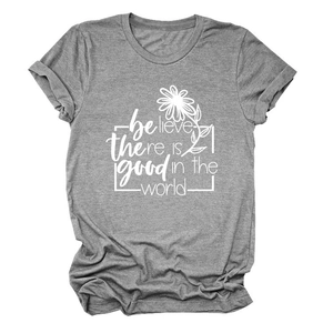 Détail d'un t-shirt gris avec une marguerite blanche et l'inscription 'believe there is good'