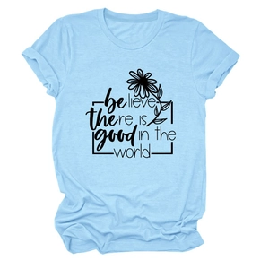 Détail d'un t-shirt bleu clair avec texte 'believe there is good' et motif floral