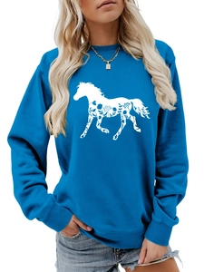 Detail of blue crewneck sweatshirt featuring white horse silhouette with floral patterns