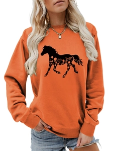 Detail view of horse silhouette with floral patterns on orange long sleeve sweatshirt